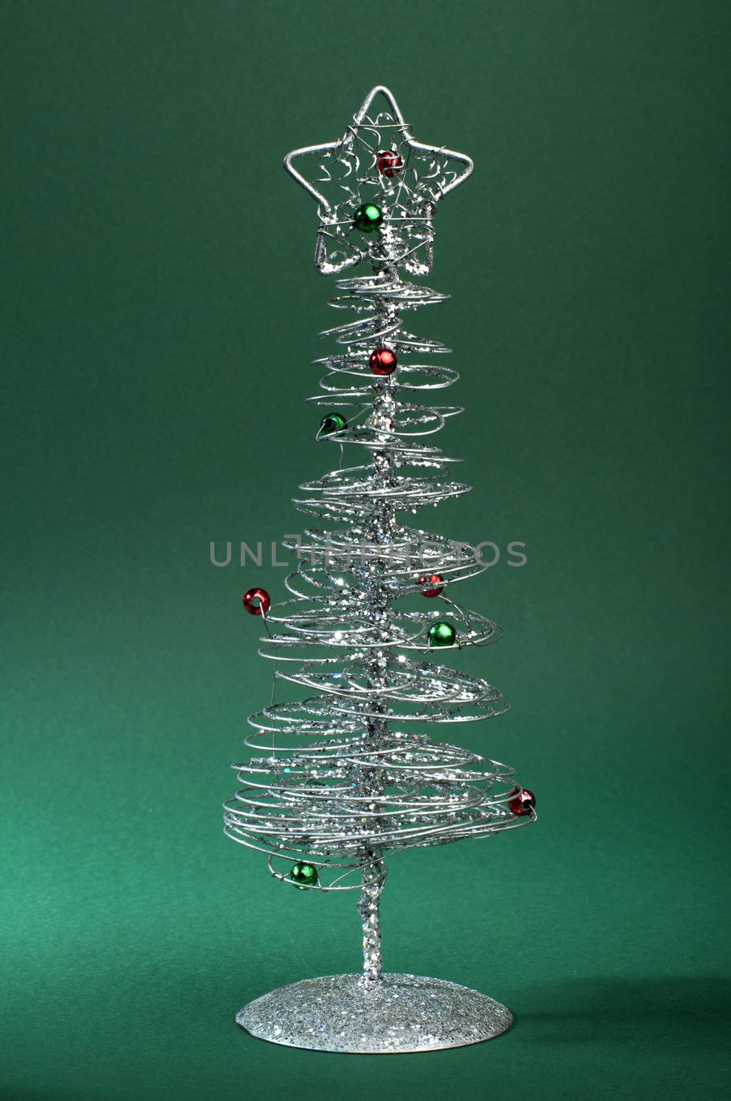 Silver Christmas tree with ornaments. Green Background