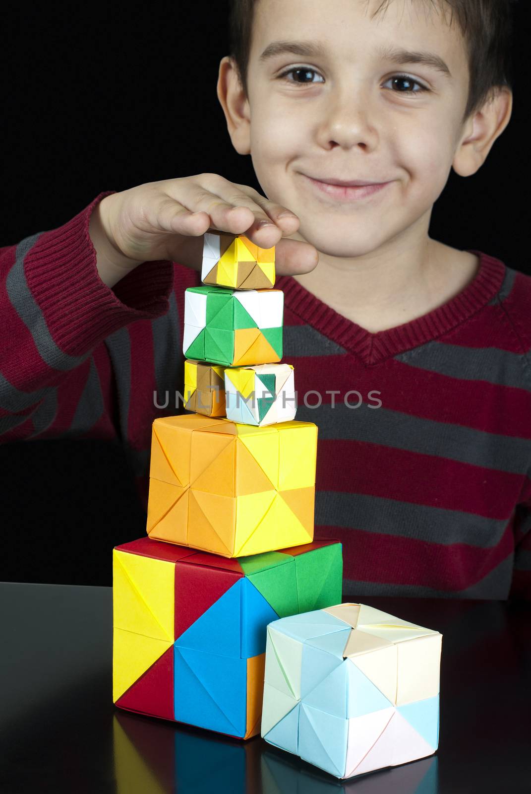 Little boy playing with multicolored cubes.