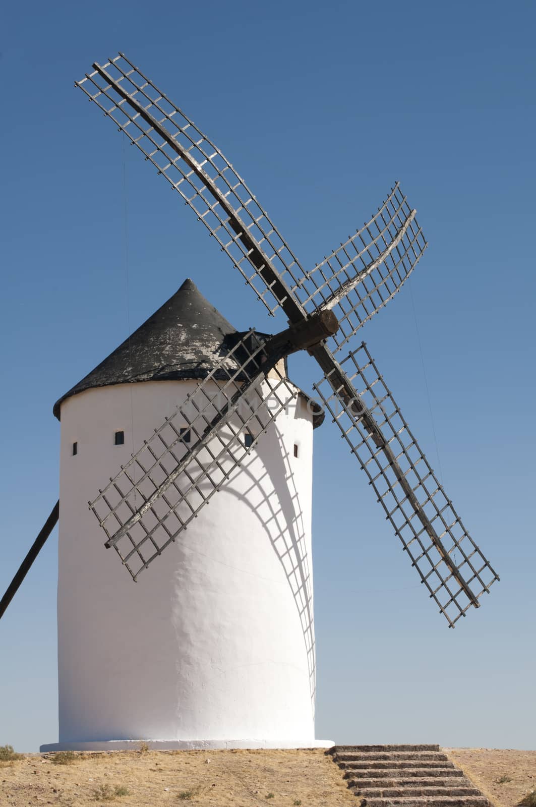 White ancient windmill. Blue sky background