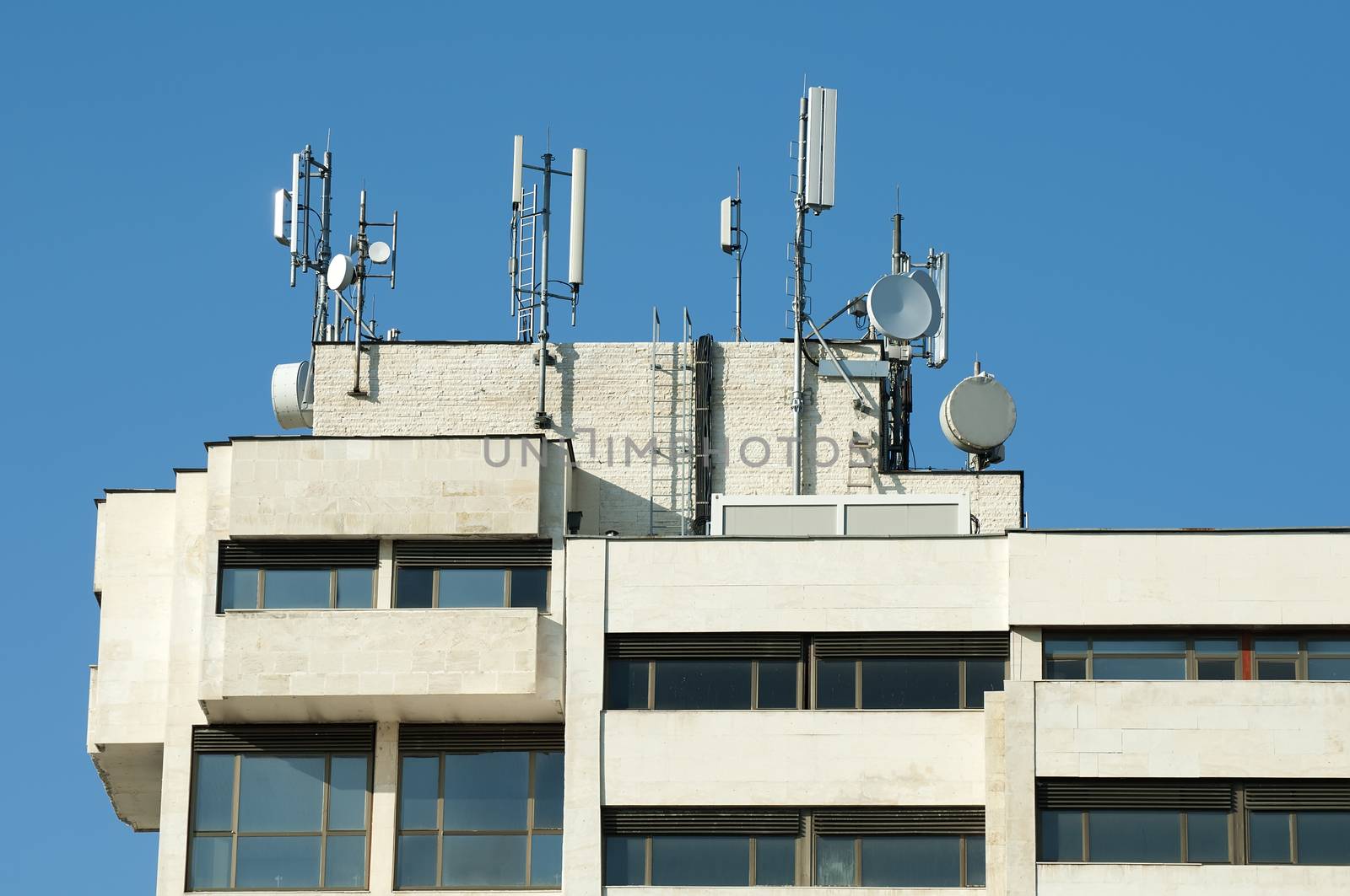 GSM transmitters on a roof of white administrative building