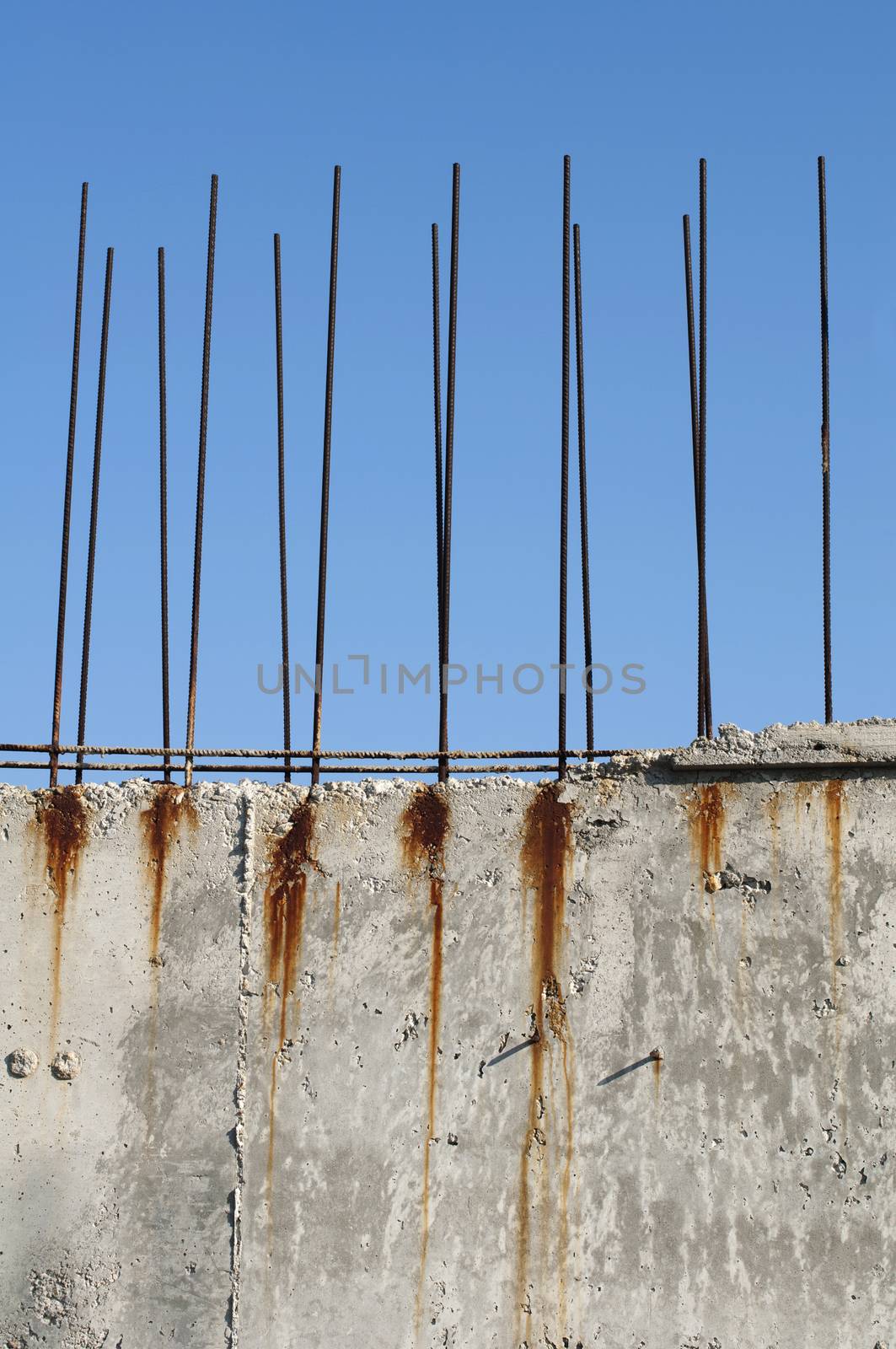 Old reinforcing steel protruding from the concrete. Blue sky background