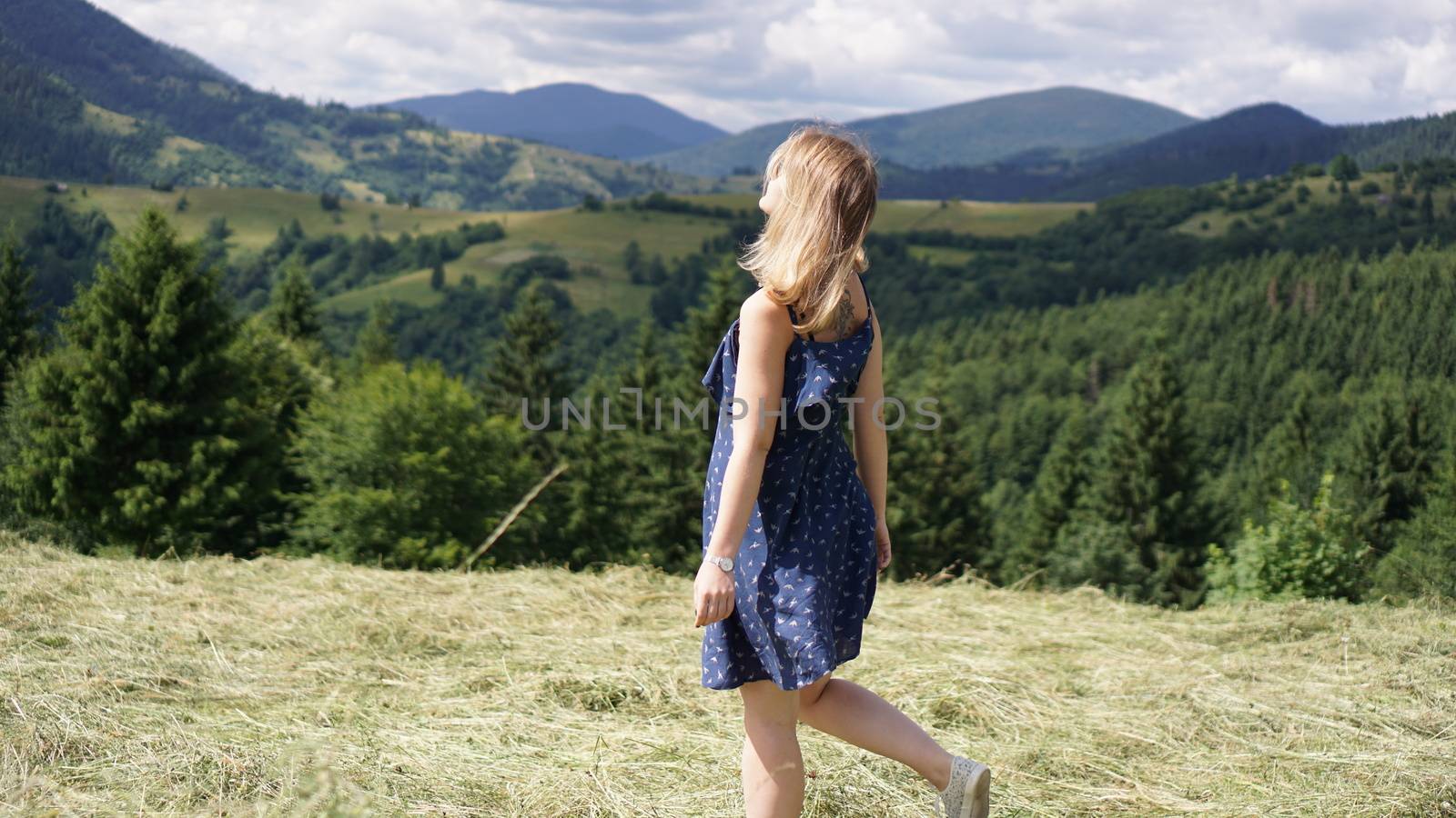 Woman standing on the mountain top looking at panoramic view of mountain range by natali_brill