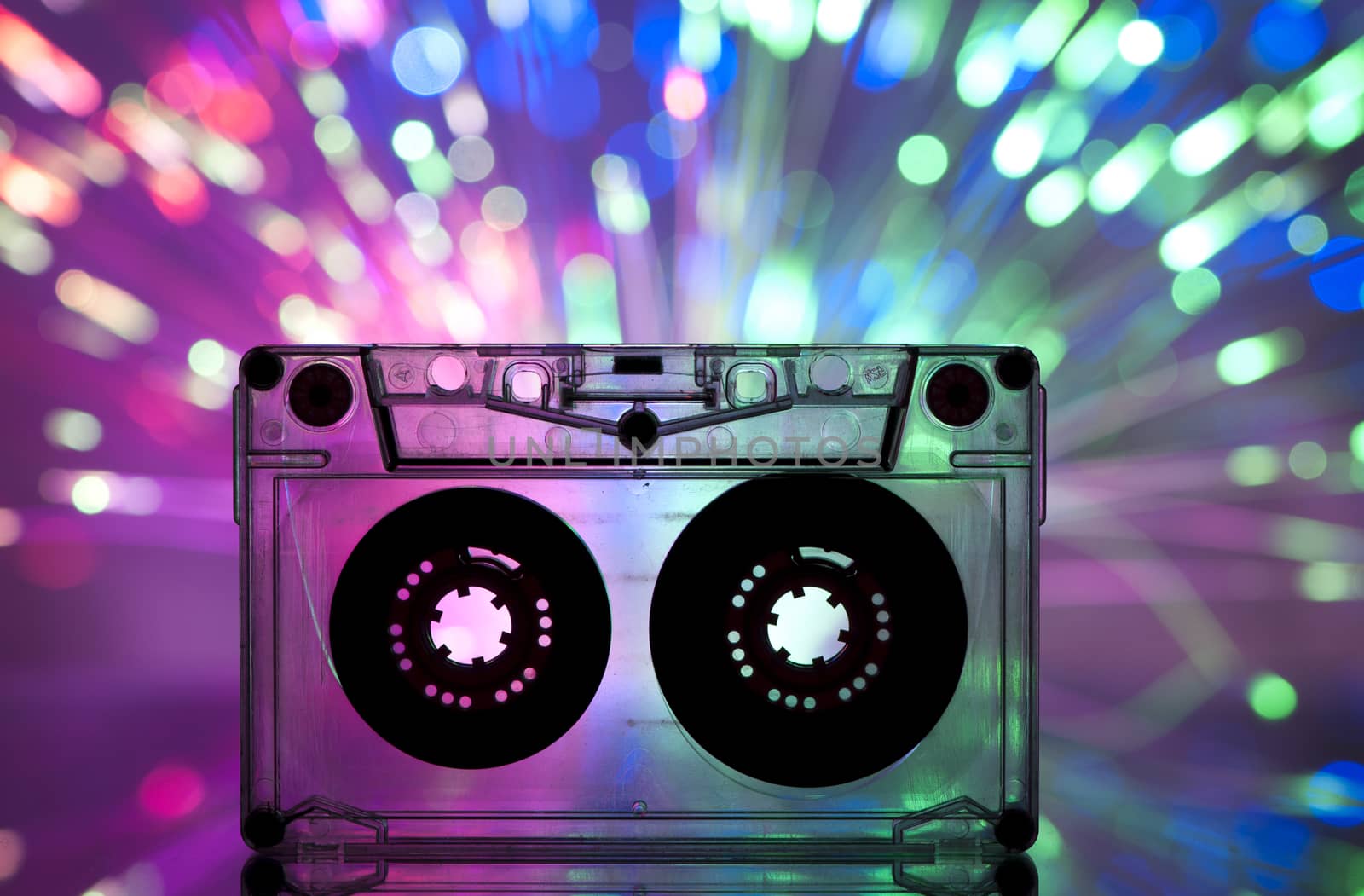 Cassette tape and multicolored pink blue lights on background