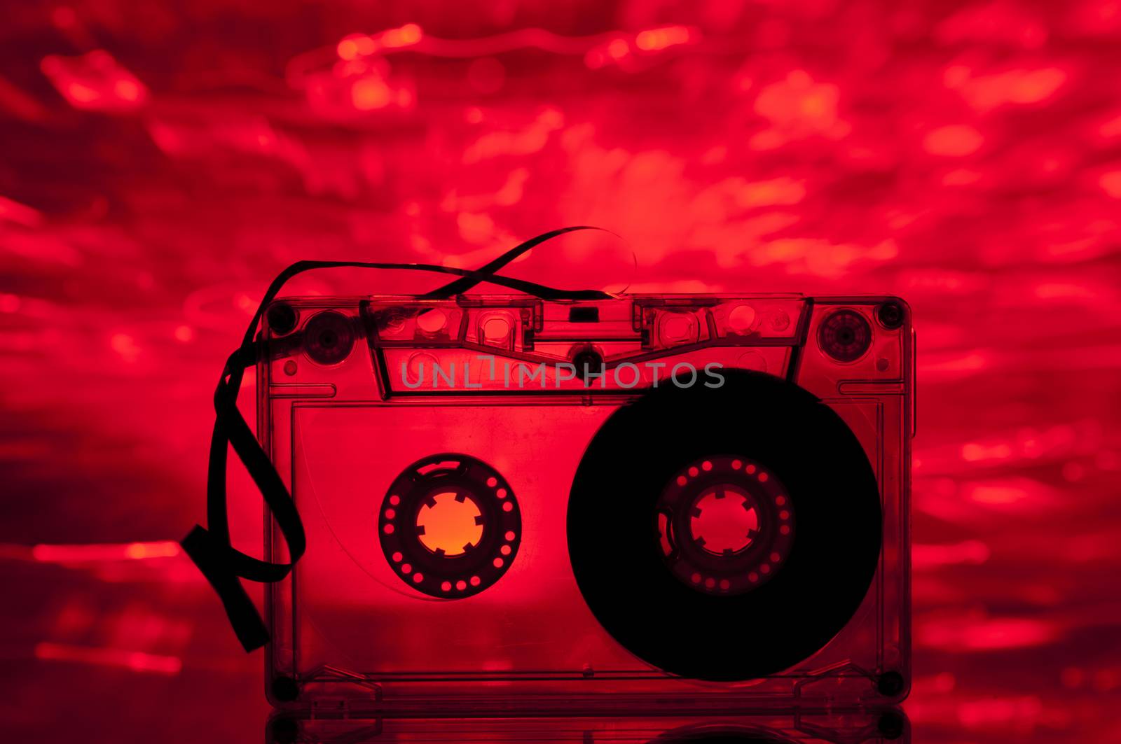 Cassette tape and multicolored lights on background
