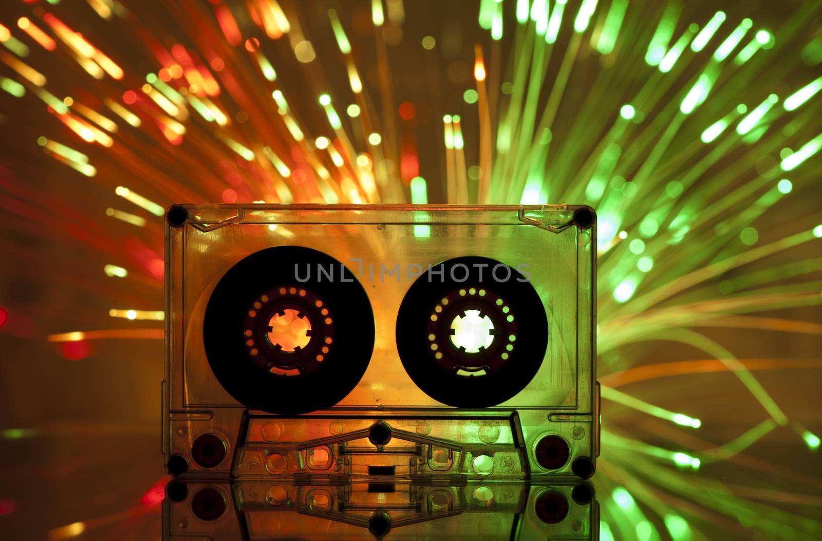 Cassette tape and multicolored yellow green lights on background