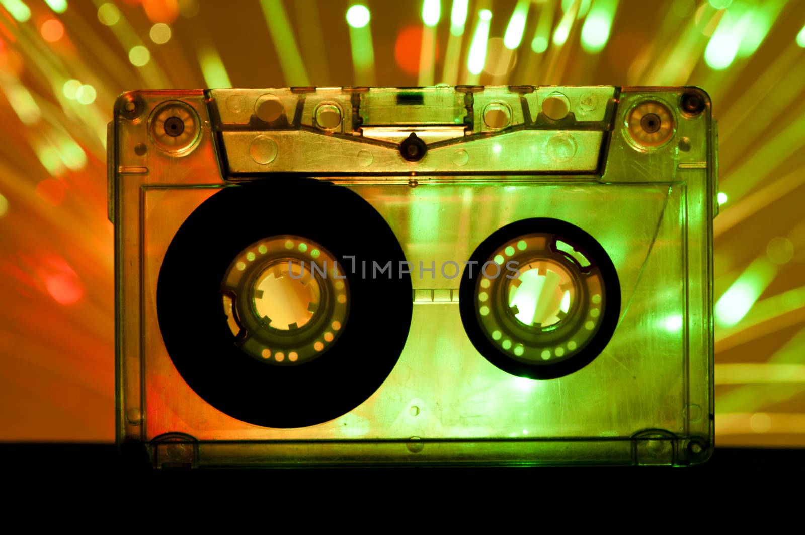 Transparent Cassette tape and green orange color disco lights background