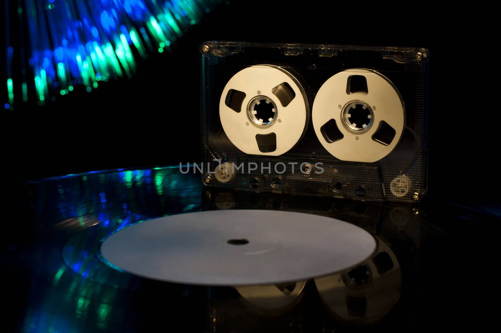 LP vinyl record, cassette tape and disco lights on background