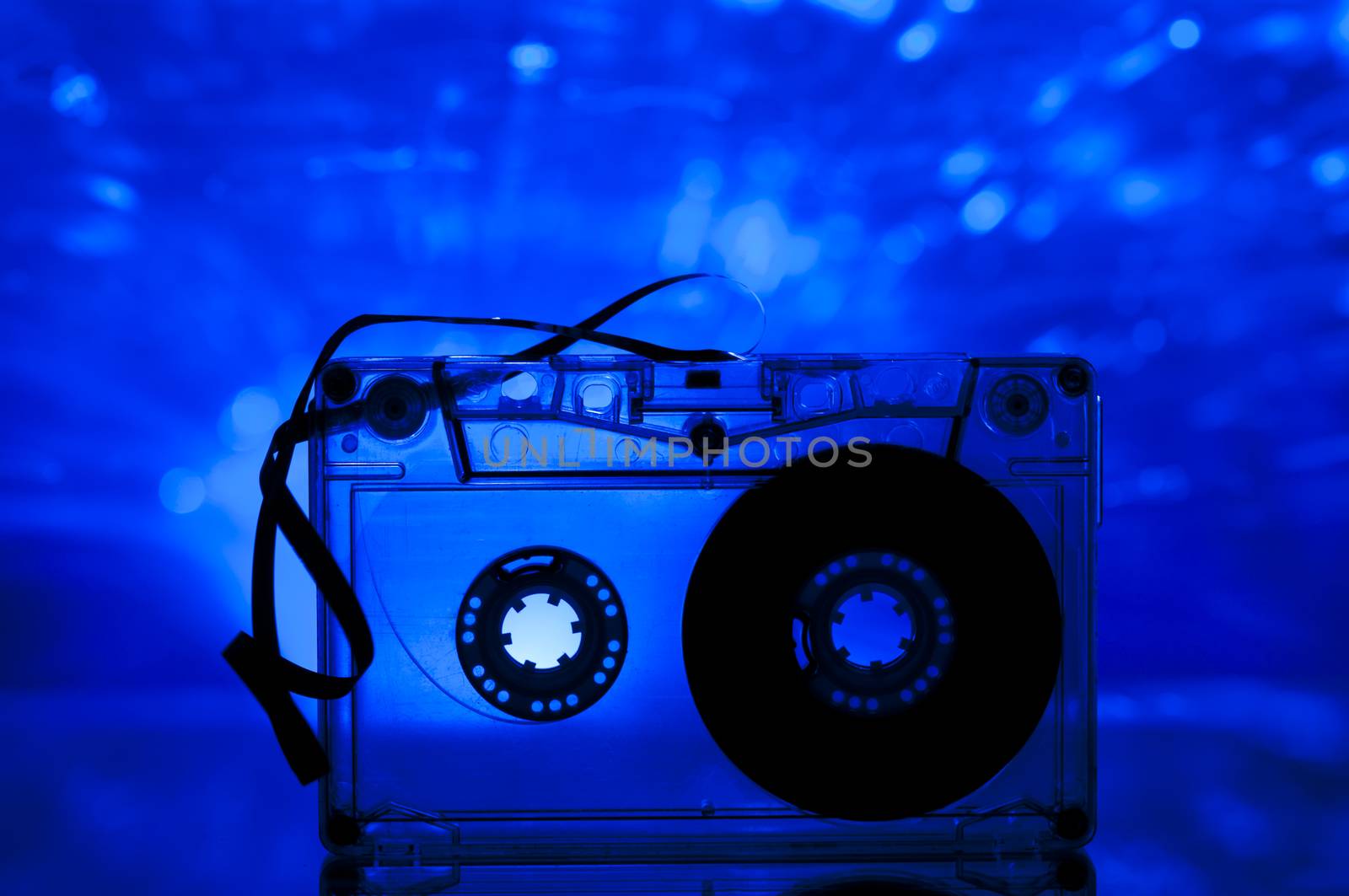 Cassette tape and multicolored blue lights on background