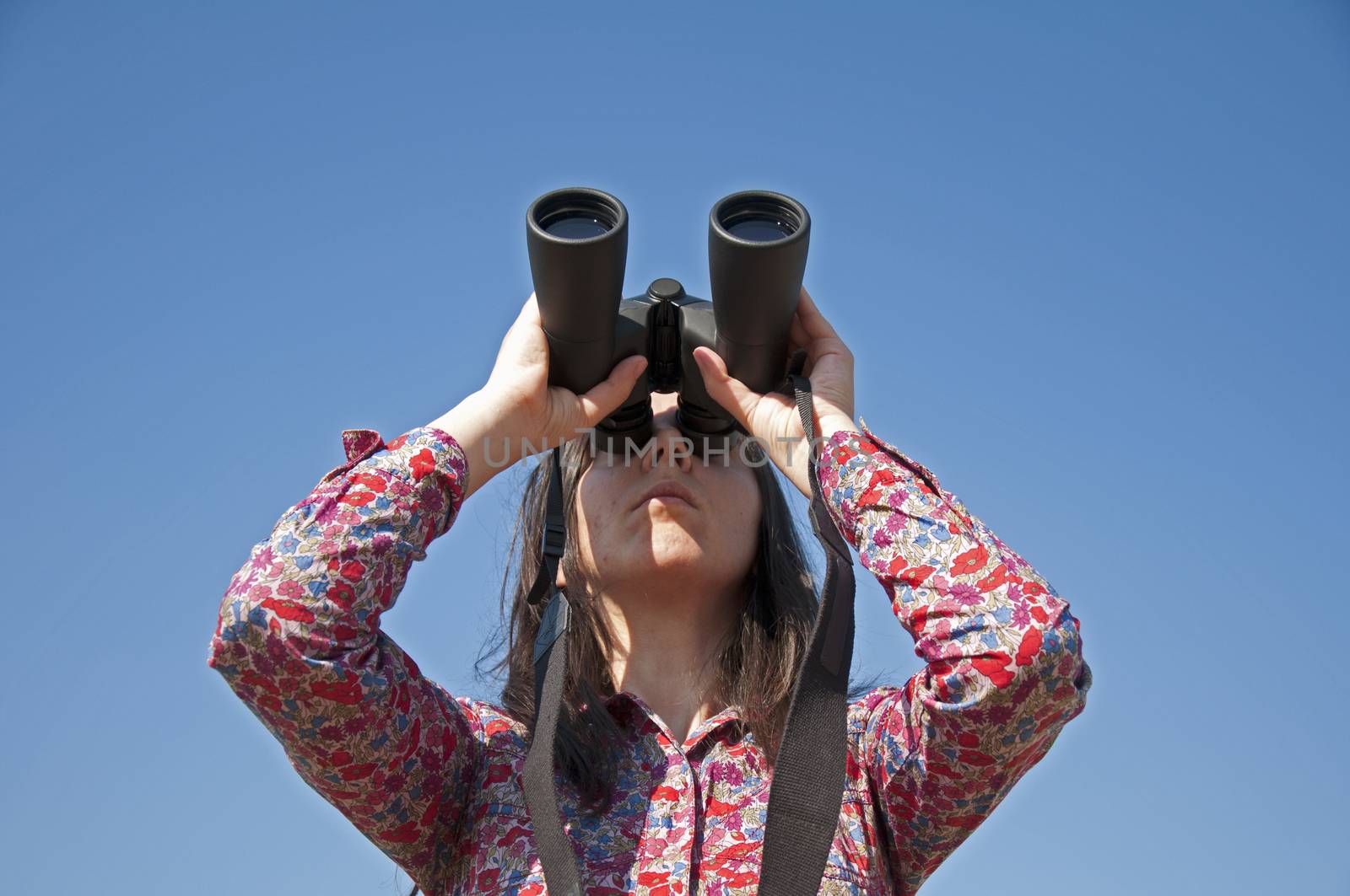 Young woman using binoculars  by deyan_georgiev