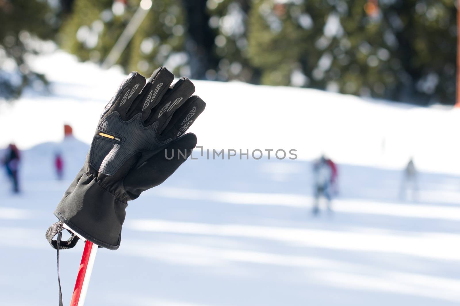 Ski gloves and sticks. Winter tourists on the background by deyan_georgiev