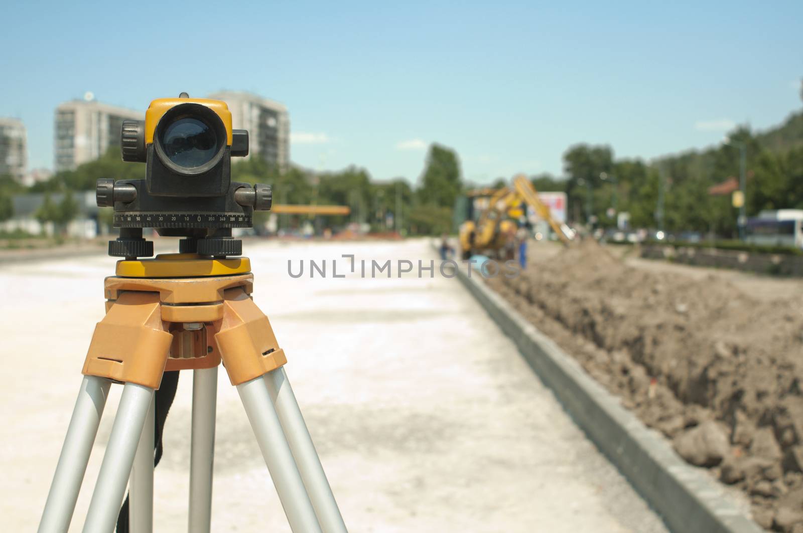 Surveying equipment to infrastructure construction project. Excavator on the background