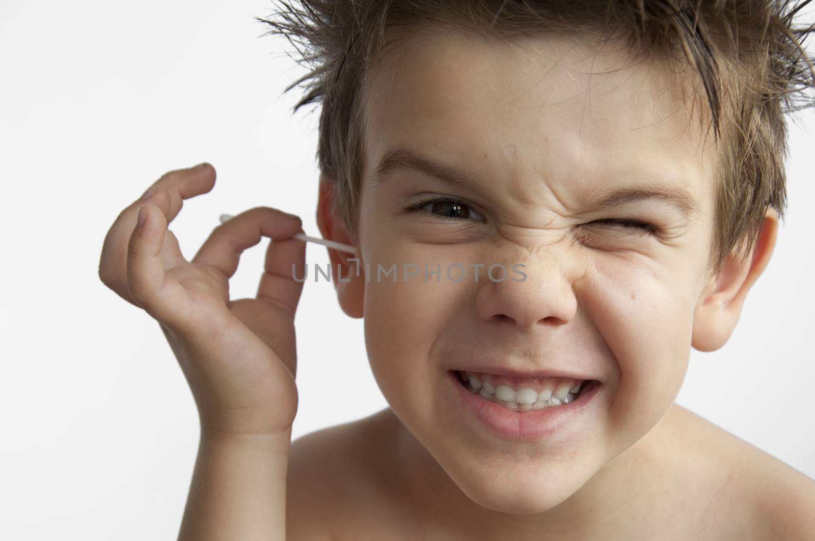 Boy cleans his ear. Isolated white background