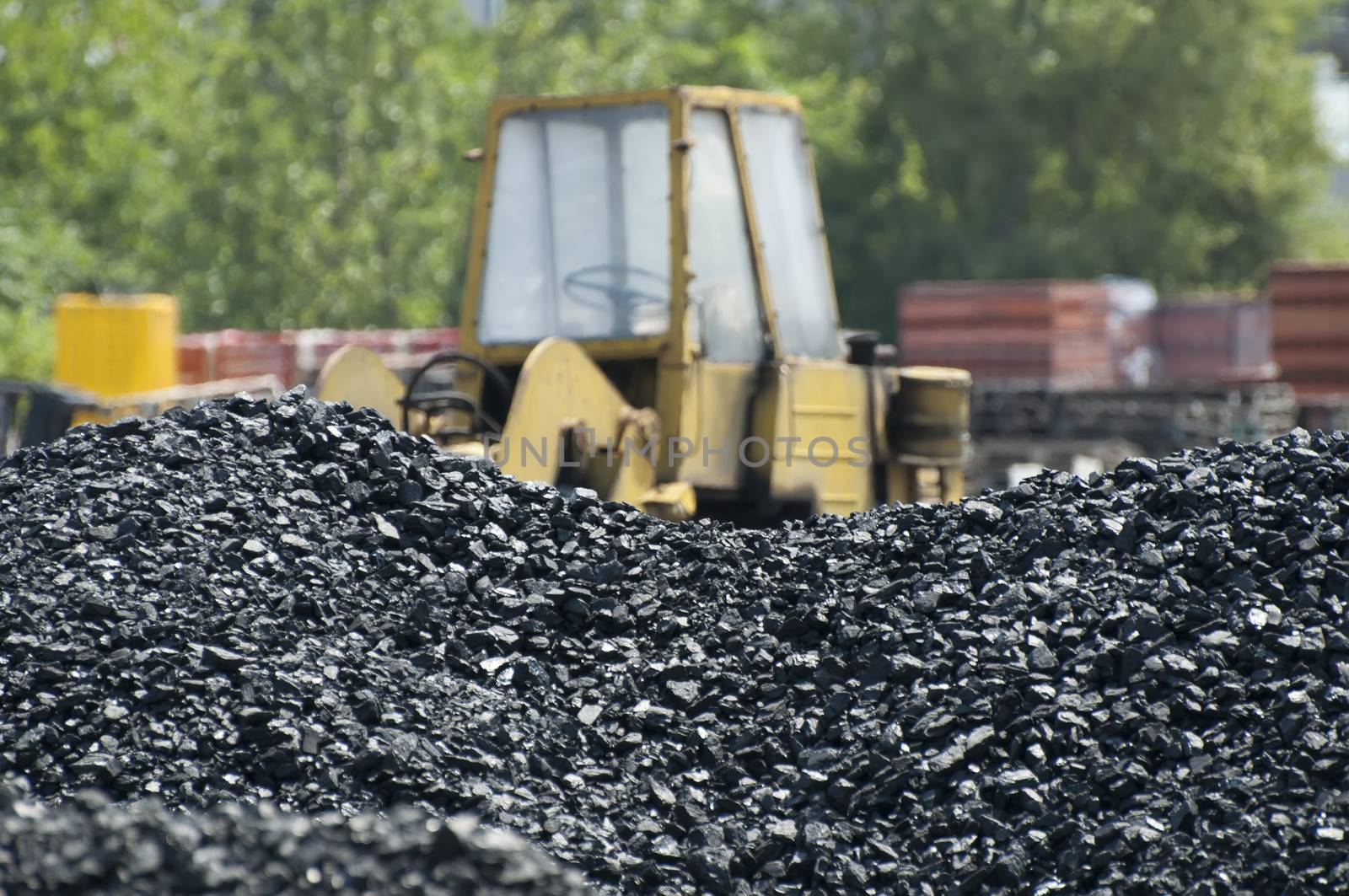 Coal piles and Excavator on background