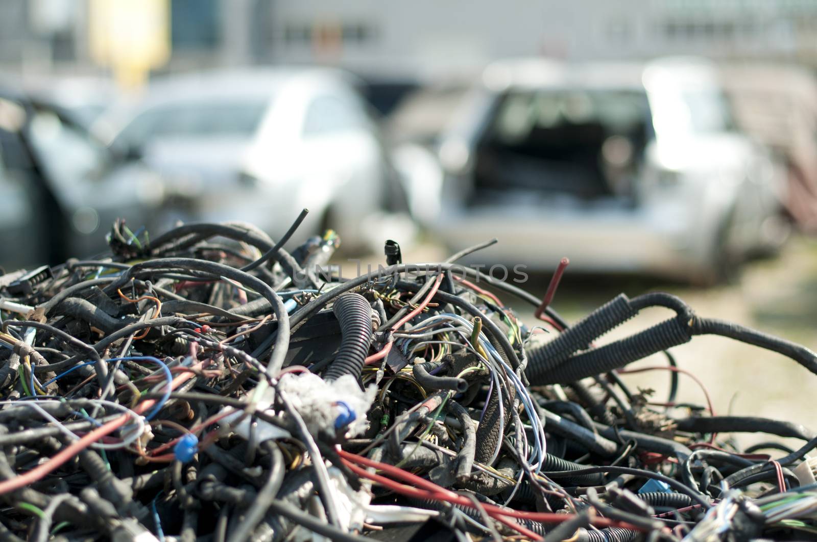 Old car parts and cables in Automorgue. Blurred cars on background 