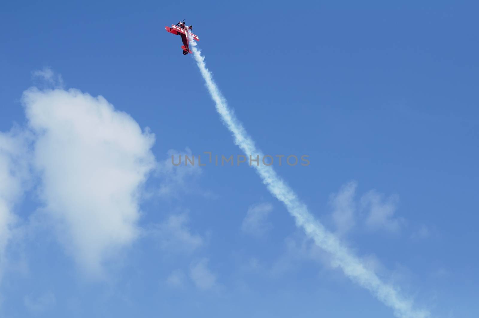Red plane looping in a blue sky. Horizontal image