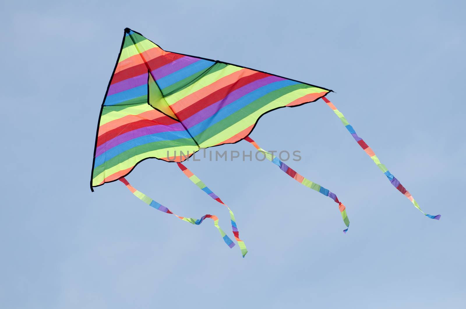 Multicolored kite on blue sky background