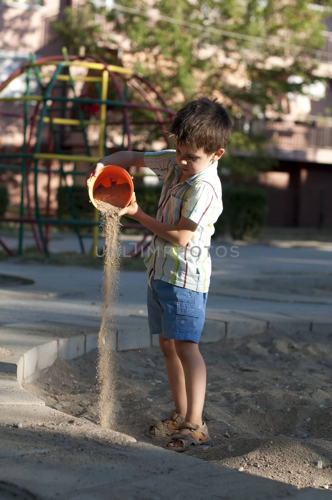 Children pour sand on playground