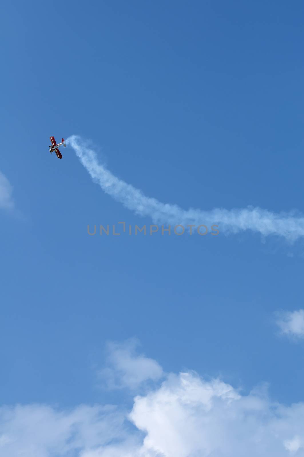 Plane doing Loops on blue cloudy sky