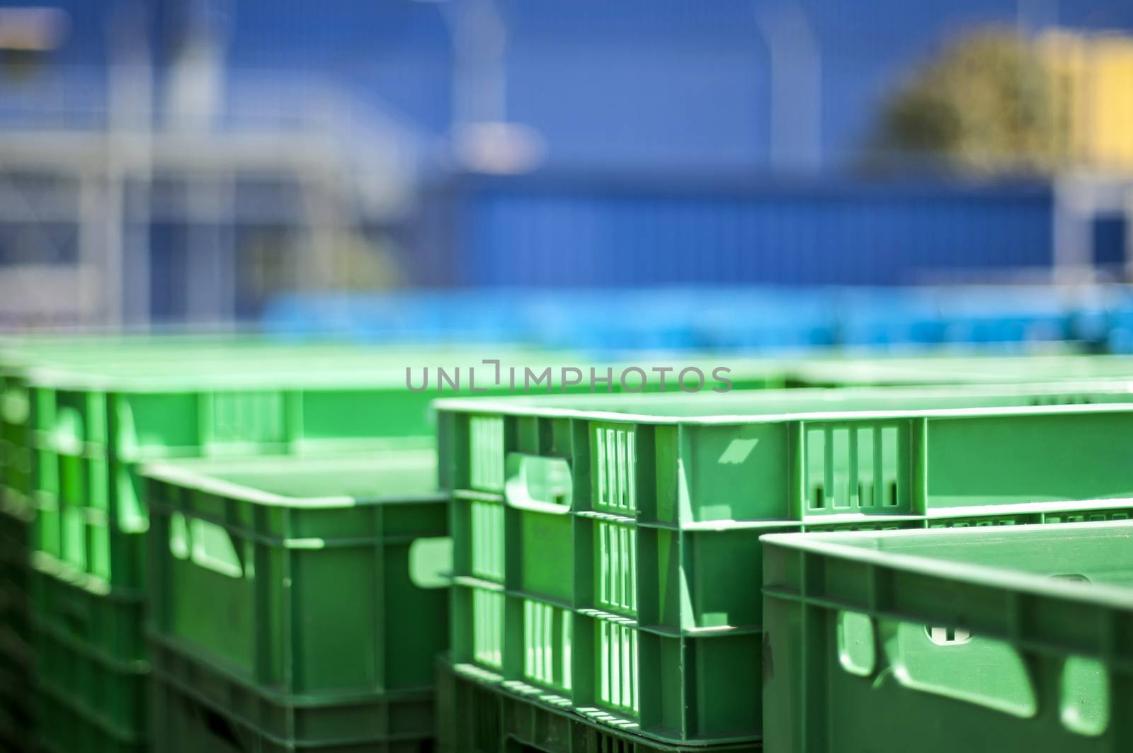 Green plastic crates. Blurred blue background