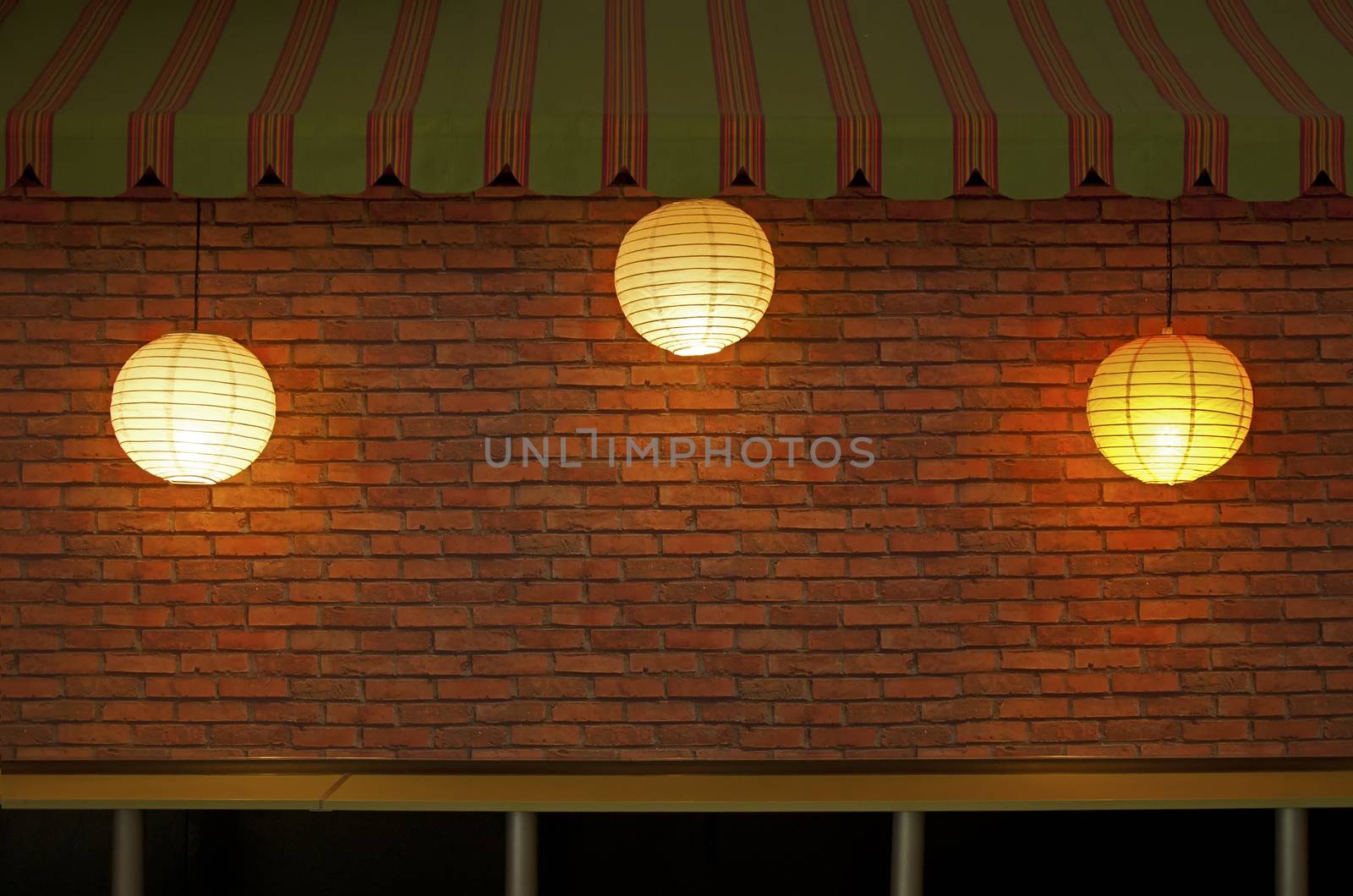 Brick wall with three illuminated lamps by deyan_georgiev