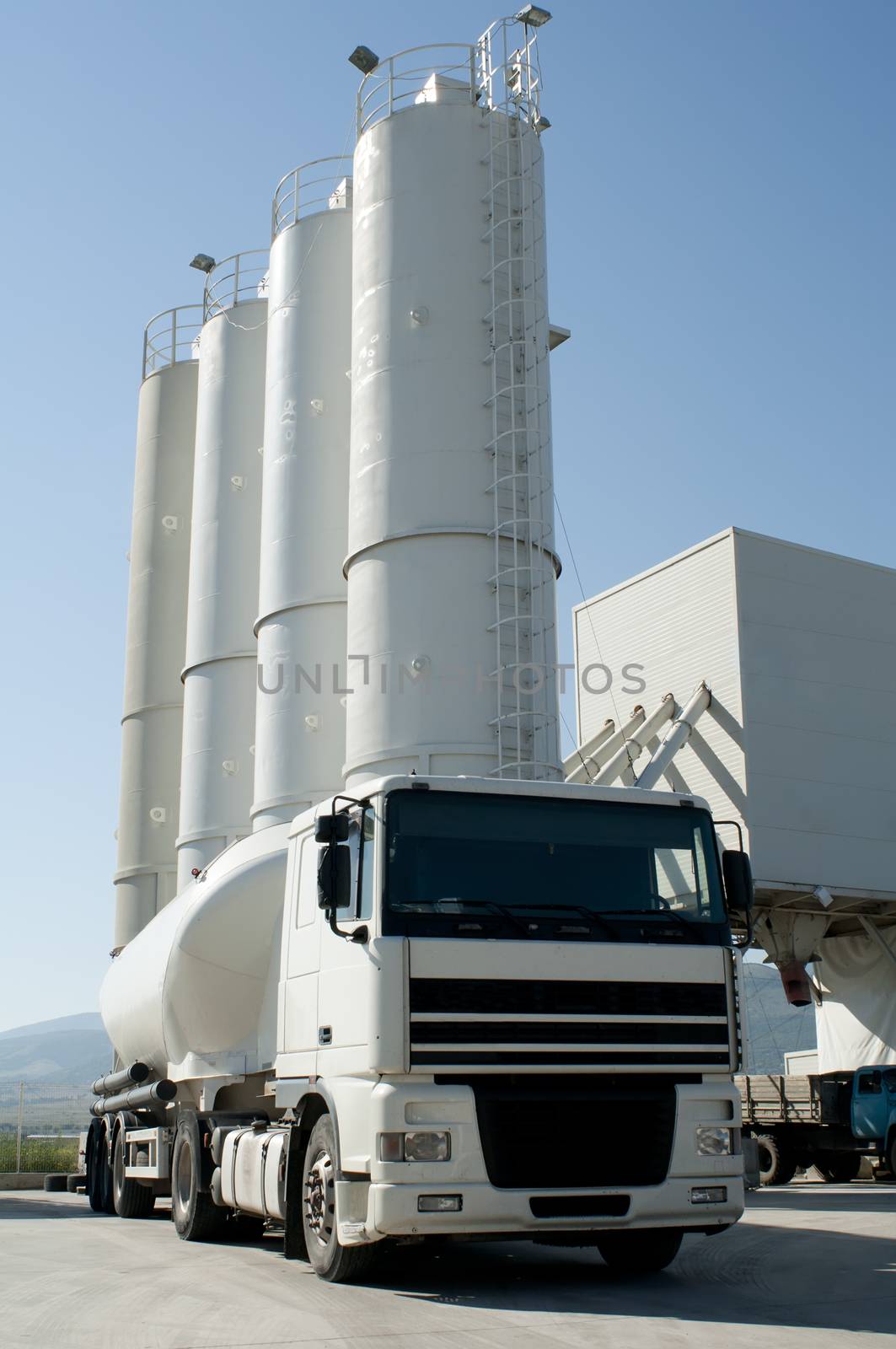 Cement factory with silos and white mixer truck