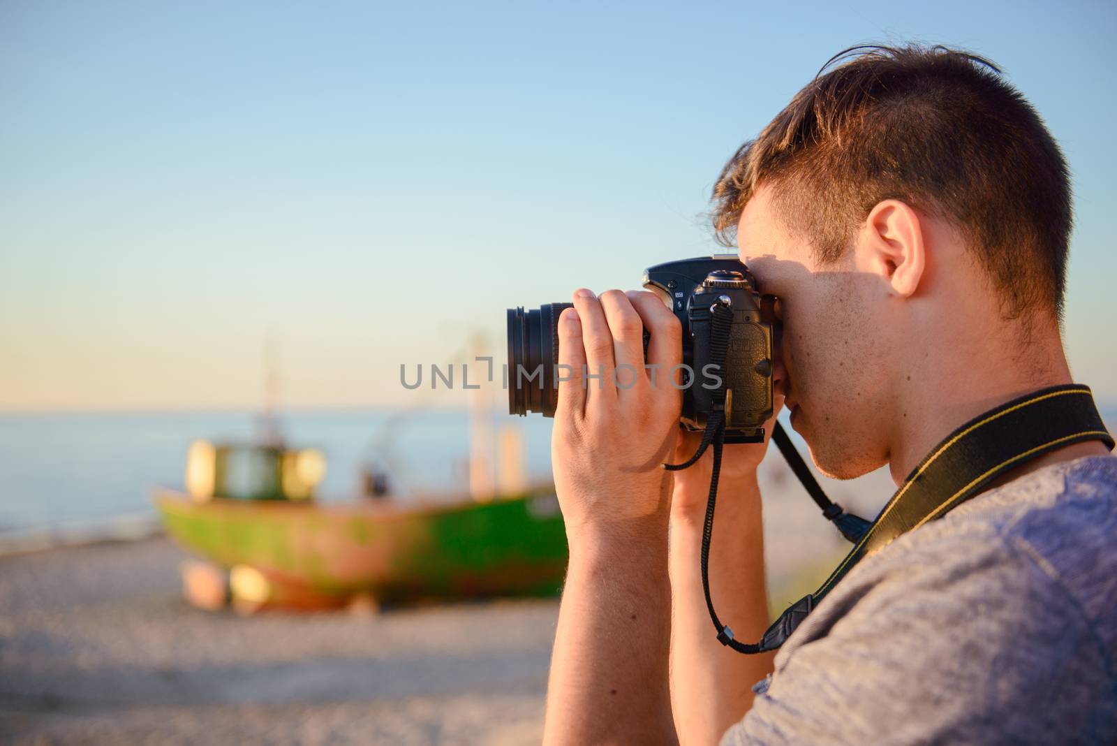 Silhouette of young photographer on the beach. Summer time