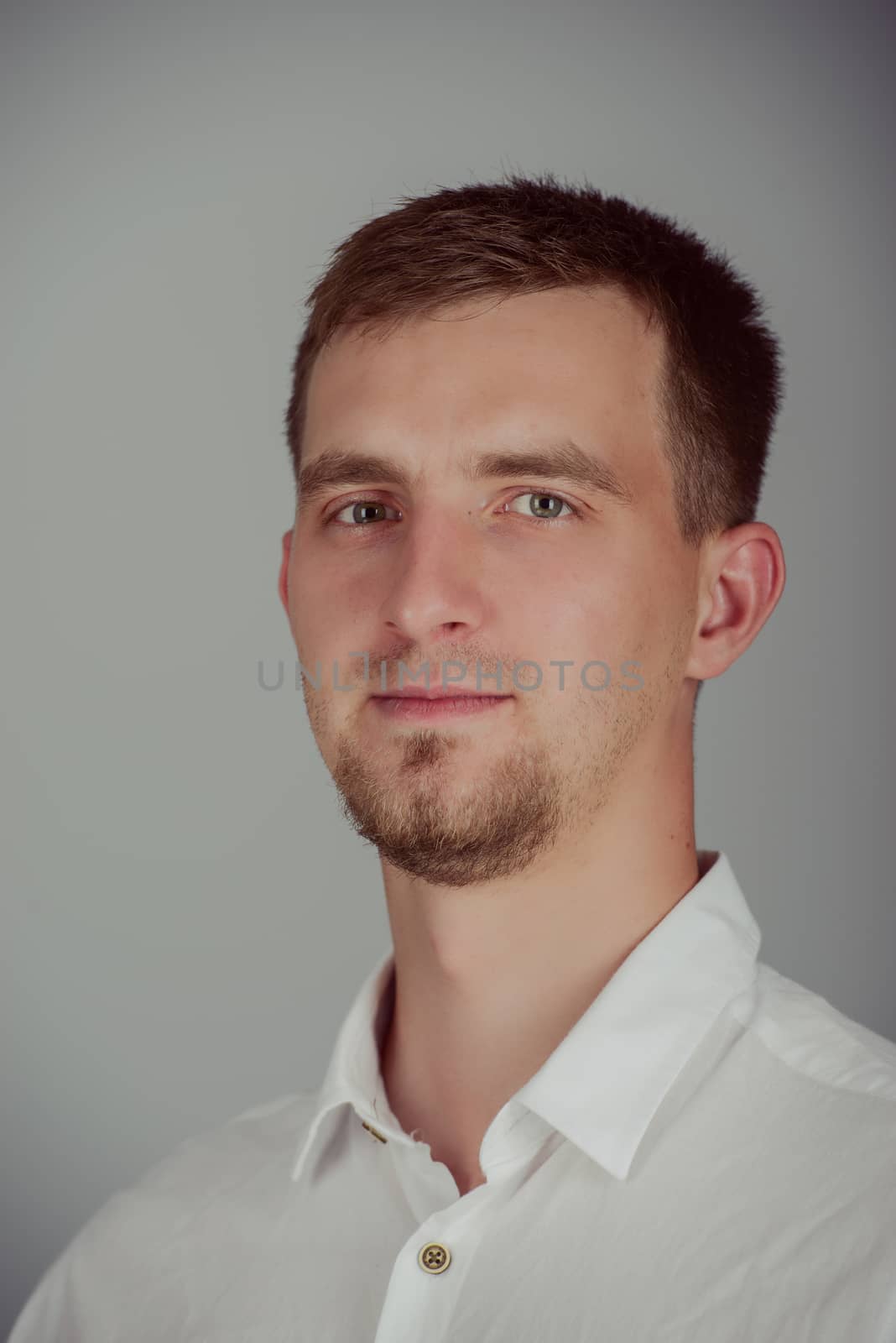 Portrait of a smiling young brunette man in studio