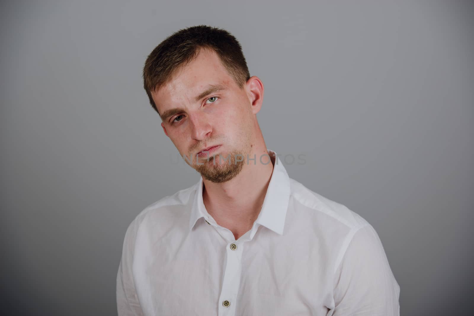 Portrait of a smiling young brunette man in studio