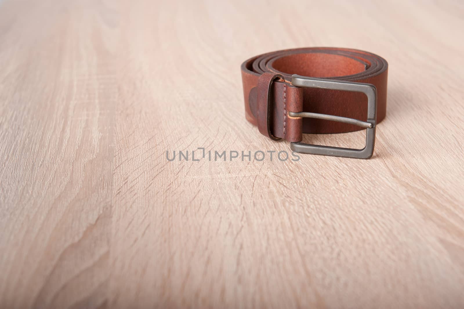 Leather belt on the wooden desk table
