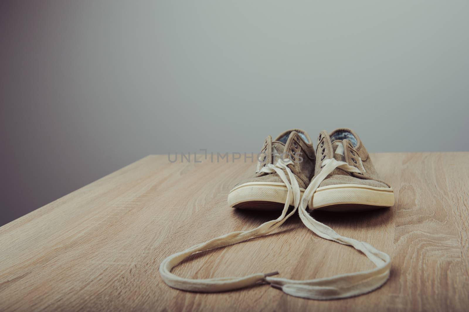 Blue lovely used sneakers on wooden desk