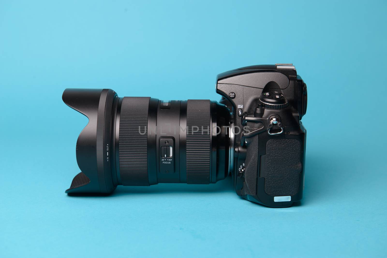 Professional modern DSLR camera against blue background