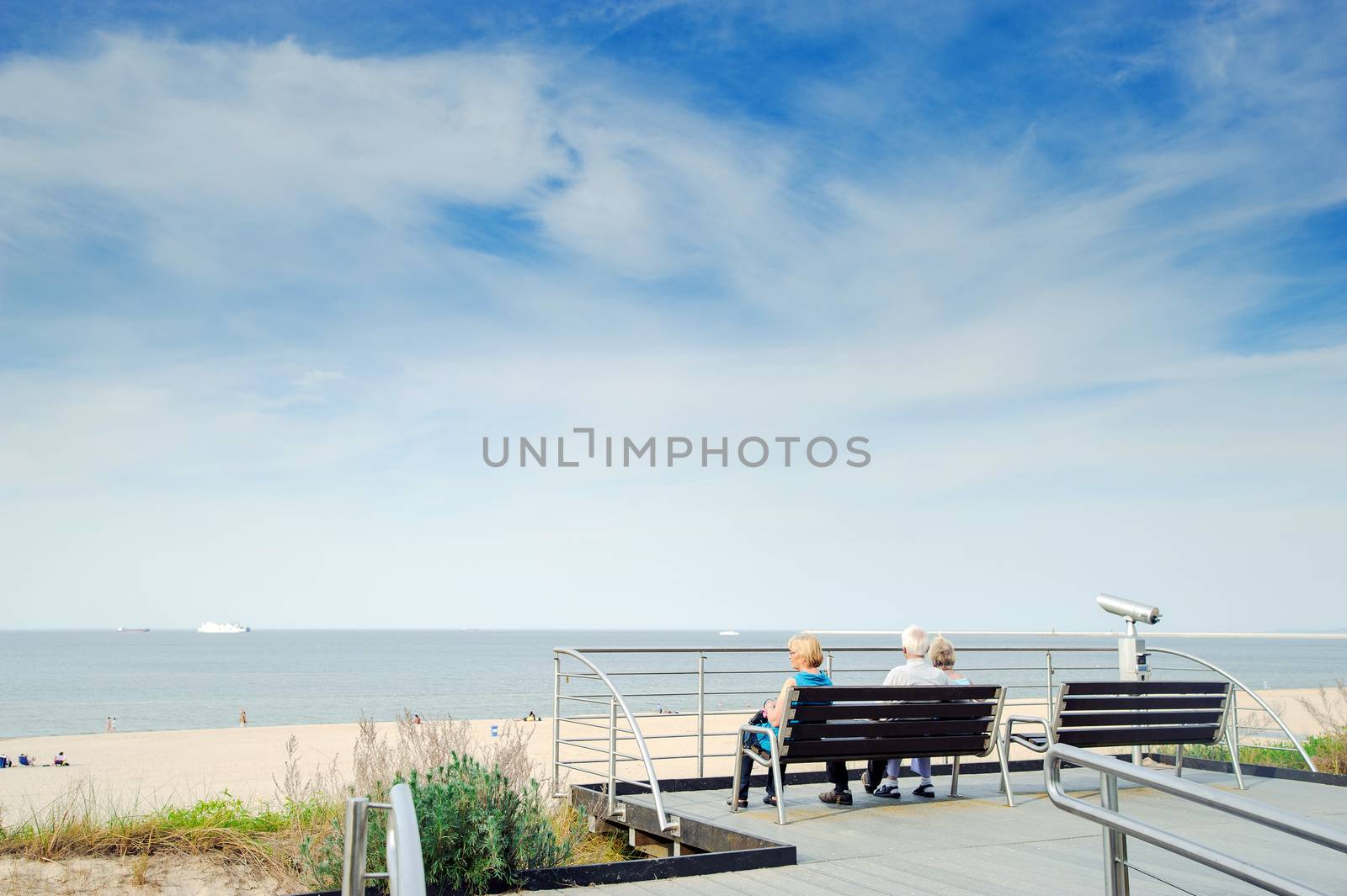 tourists sit on a bench at the beach