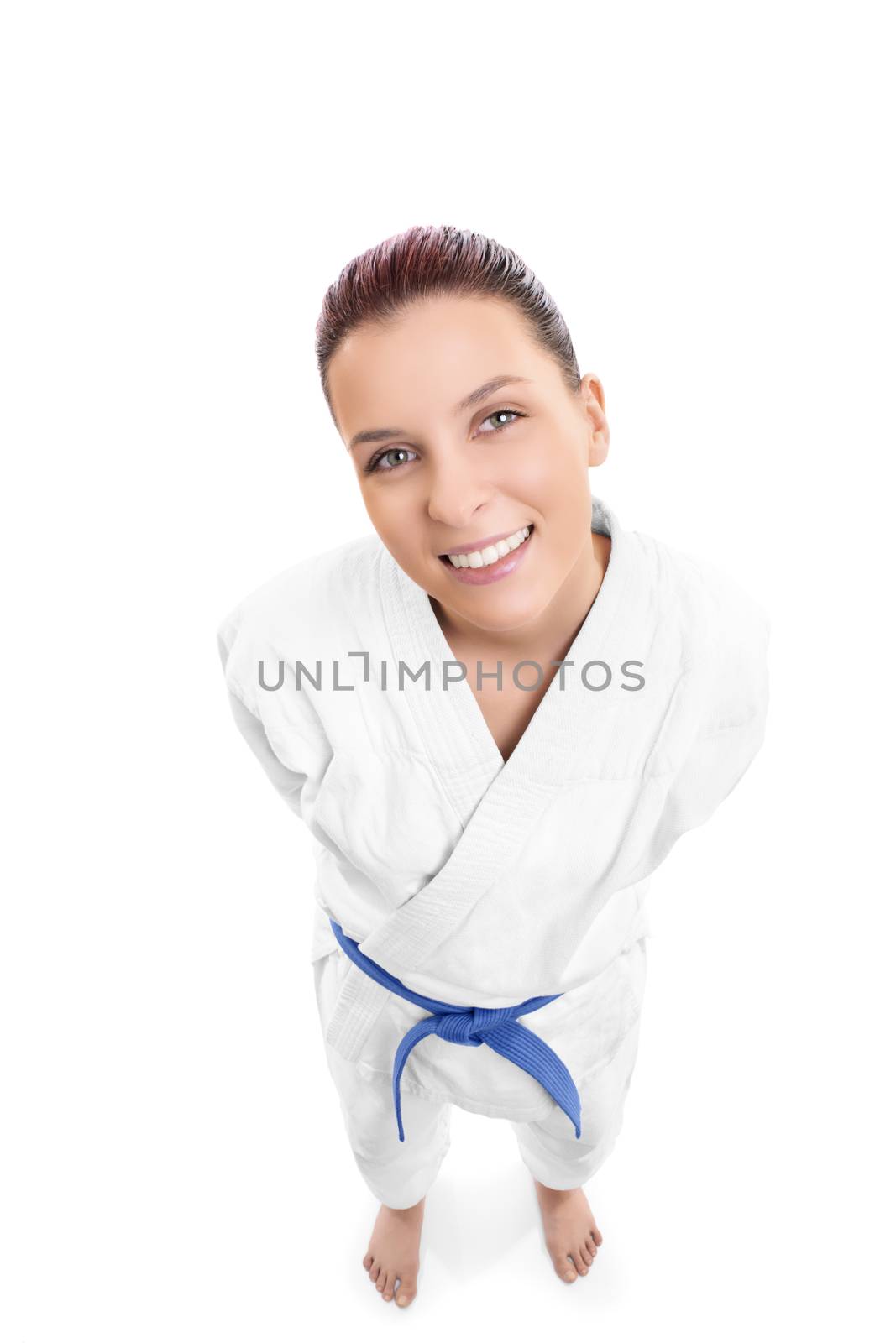Top down portrait of a beautiful young female fighter in white kimono smiling, isolated on white background.