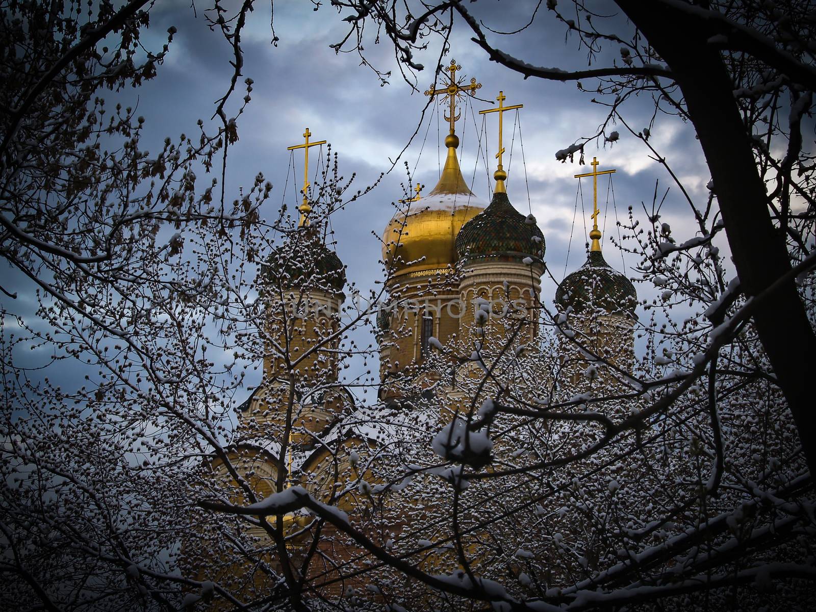 Church with Golden crosses is surrounded by snow-covered trees. by bonilook