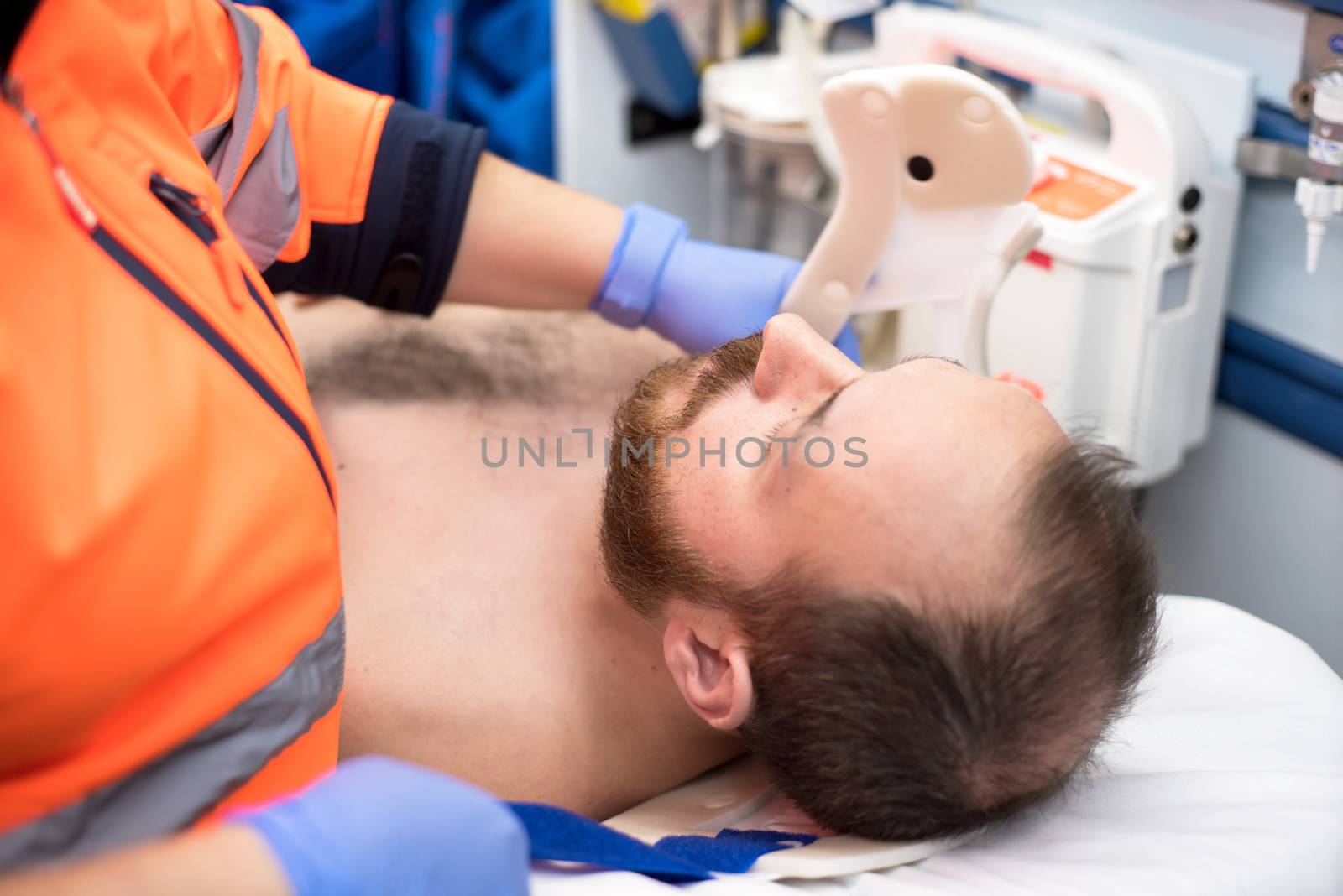 Emergency doctor putting a cervical collar to a patient in the ambulance by HERRAEZ