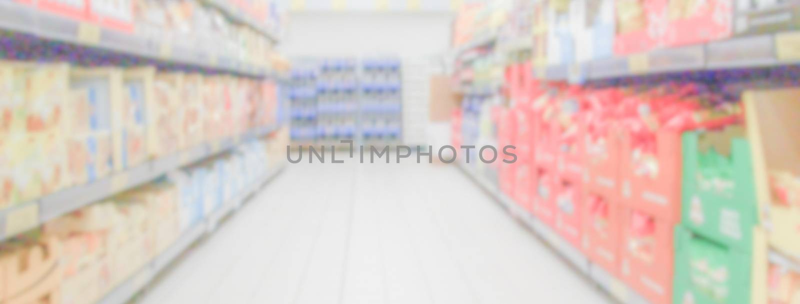 Defocused background within the aisles full of grocery goods in a supermarket or hypermarket convenience store. Intentionally blurred post production for bokeh effect