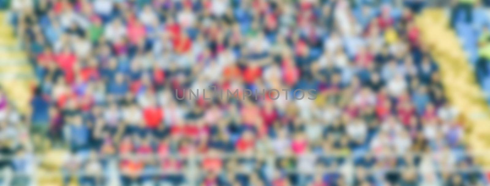 Defocused background with supporters in the stadium for football match. Intentionally blurred post production for bokeh effect