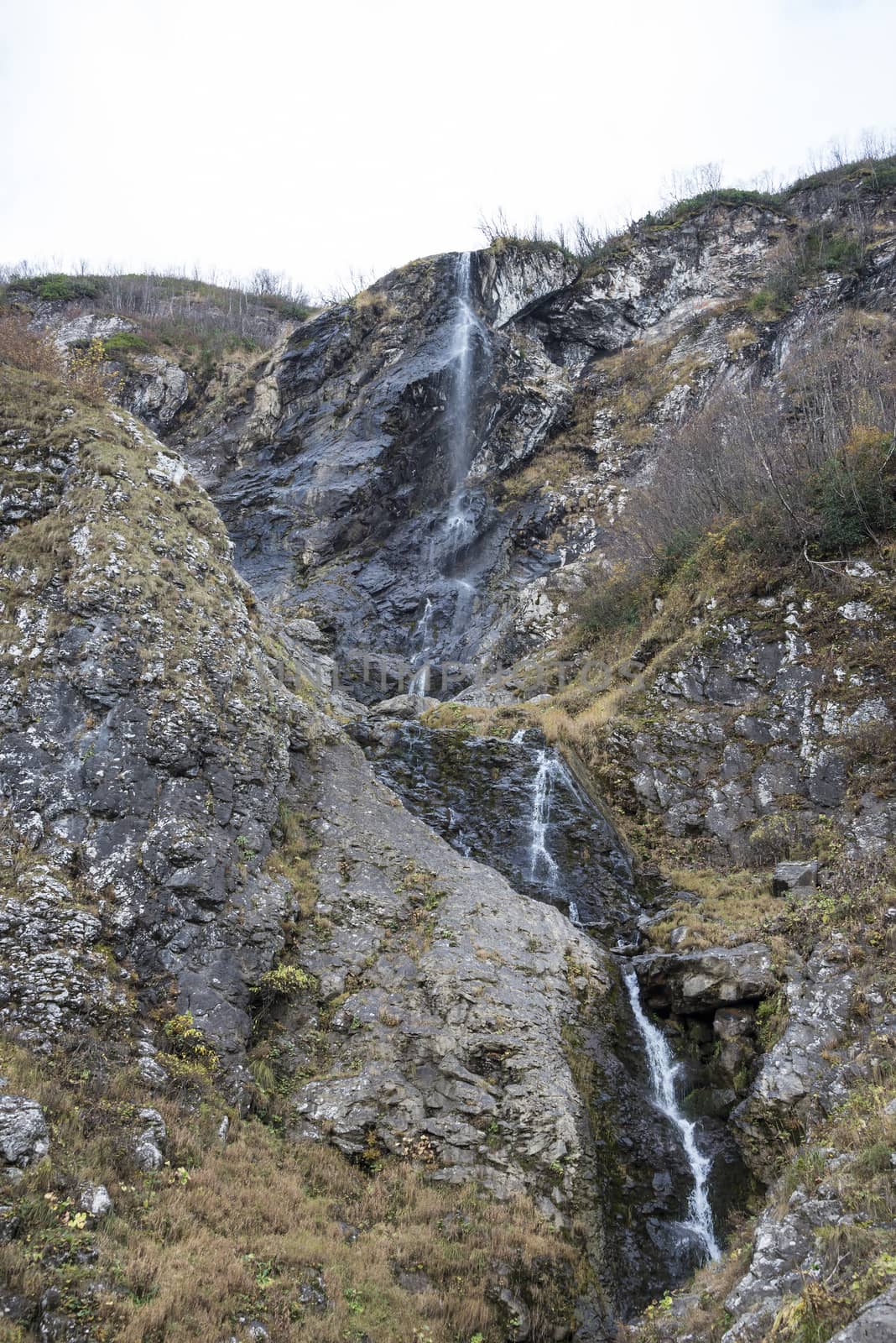 Polikarya waterfall in the Caucasus mountains near Sochi, Russia. Cloudy day 26 October 2019 by butenkow