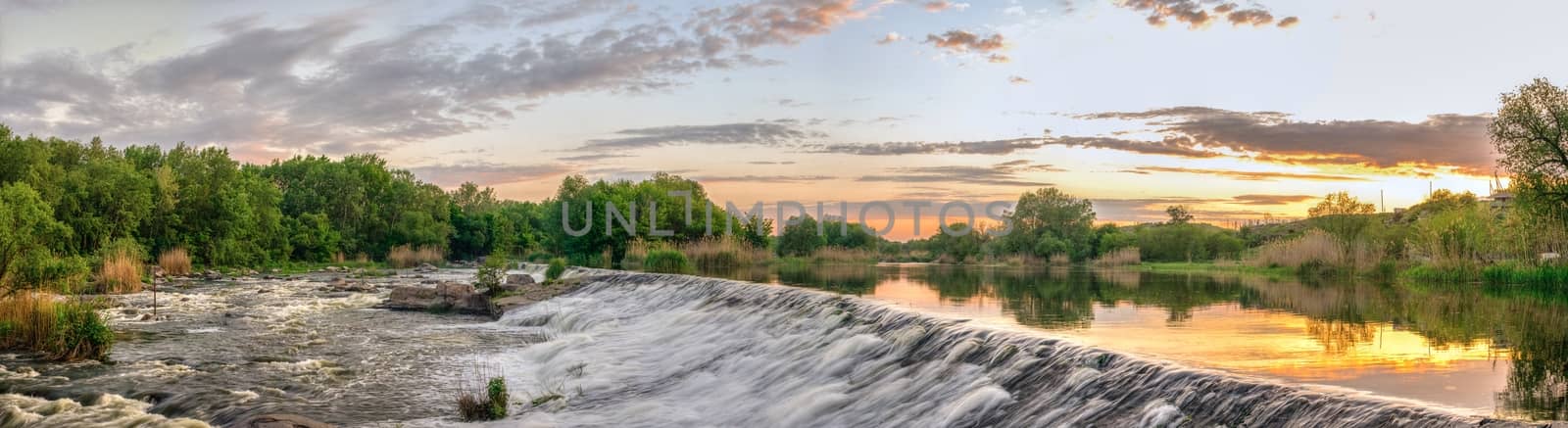 Beautiful view of the dam on the Southern Bug River at sunset. Village of Migiya, Ukraine, on a sunny summer evening