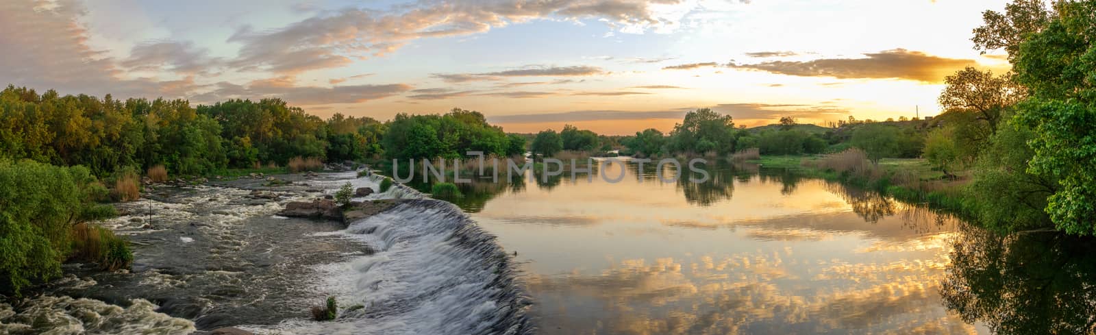 Beautiful view of the dam on the Southern Bug River at sunset. Village of Migiya, Ukraine, on a sunny summer evening