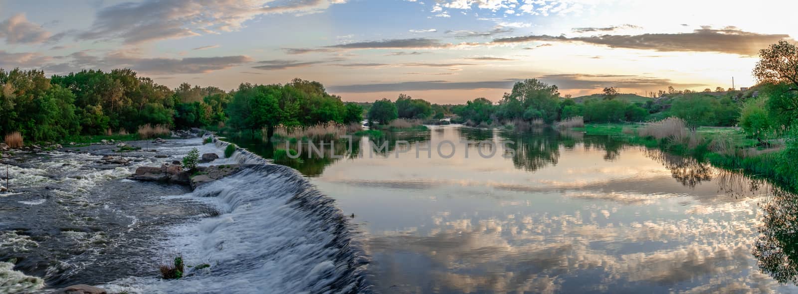 Beautiful view of the dam on the Southern Bug River at sunset. Village of Migiya, Ukraine, on a sunny summer evening