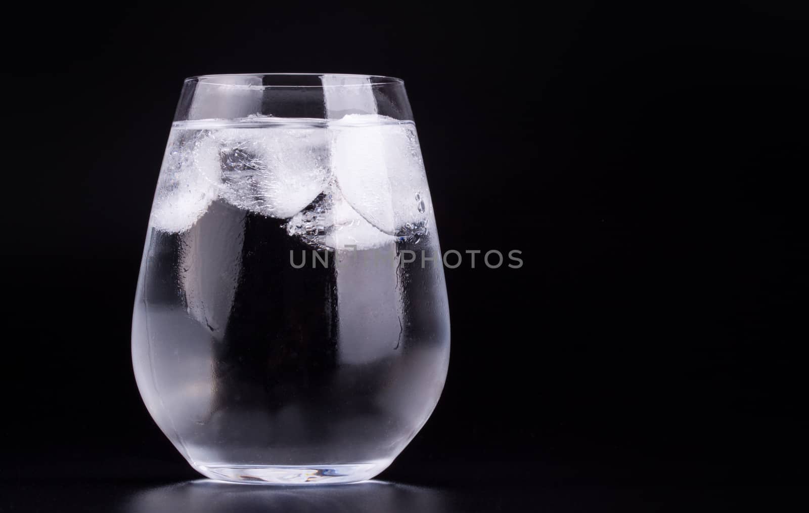 Glass of water with ice cubes by lanalanglois