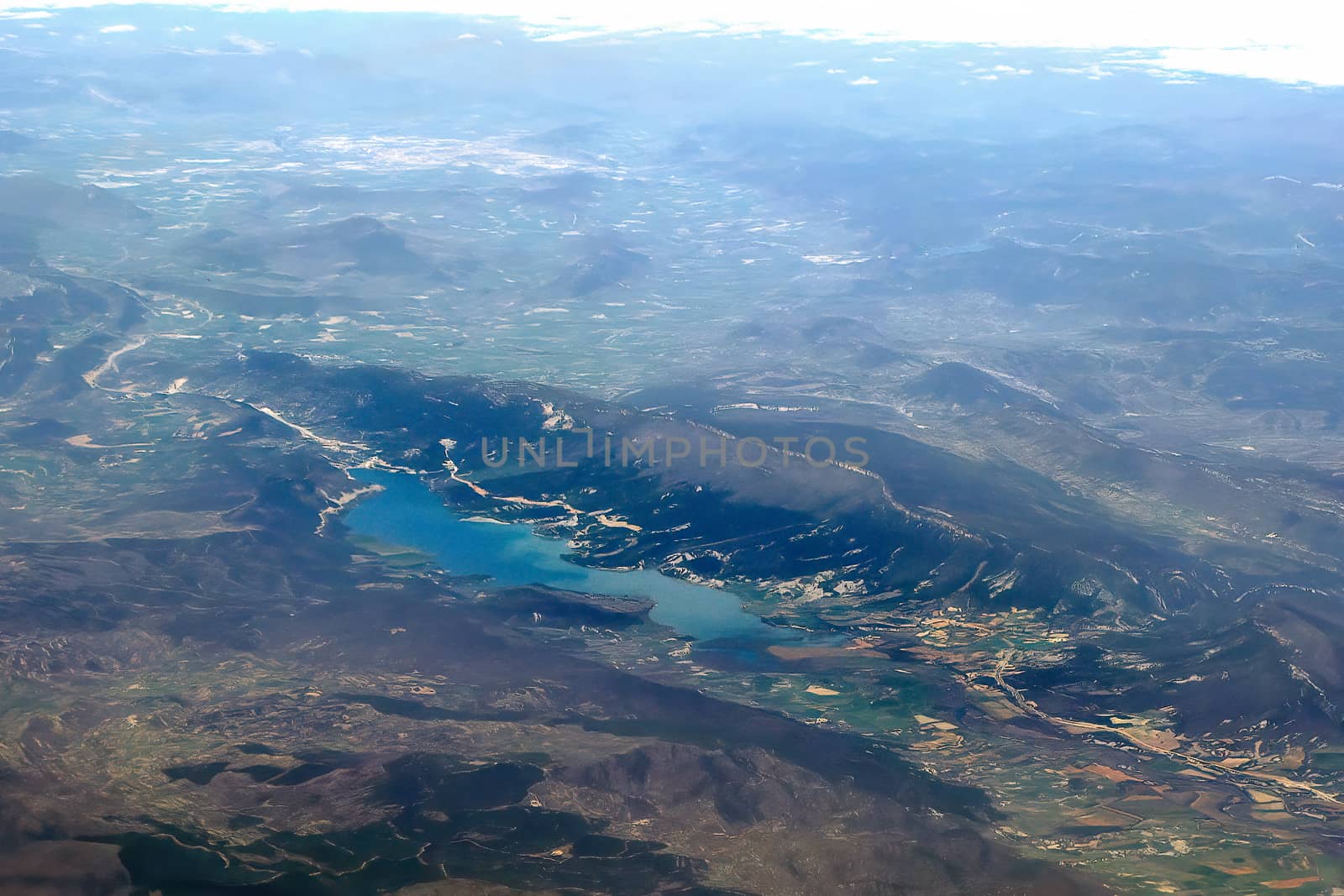 Top view of the ground from the plane. European landscape. Colorful pattern of trees, fields, rivers and lakes. Soft focus.