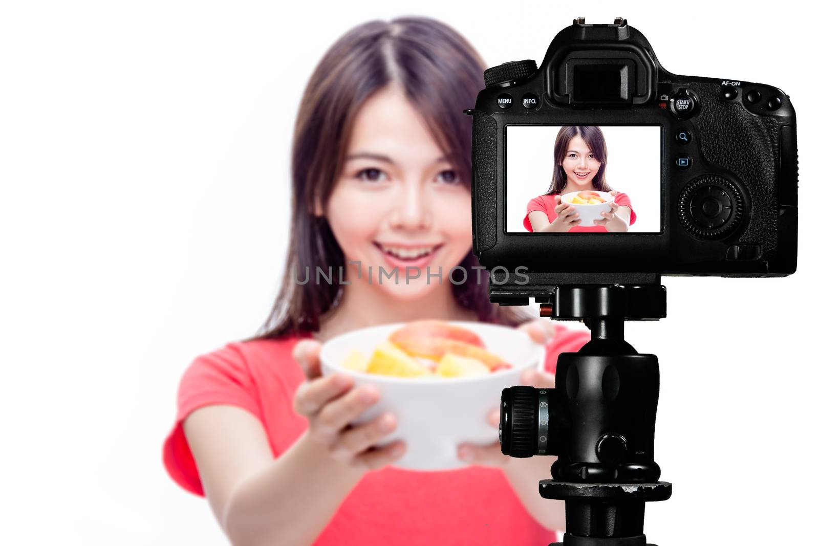 Asian food vlogger with fruit salad behind camera, social media production concept