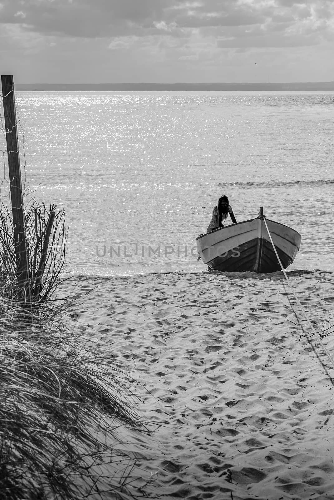 Silhouette of a young and nice girl on the boat at the seaboard