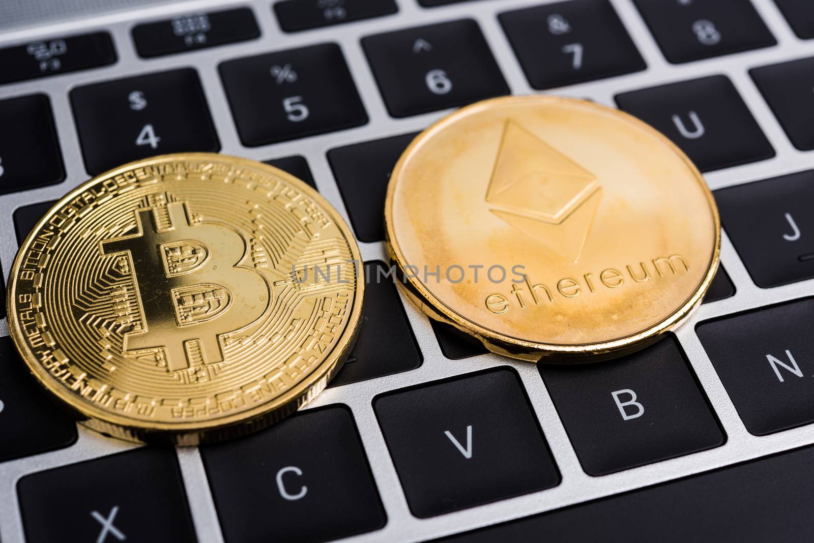 Virtual Bitcoin and Ethereum coins currency finance money on computer laptop keyboard