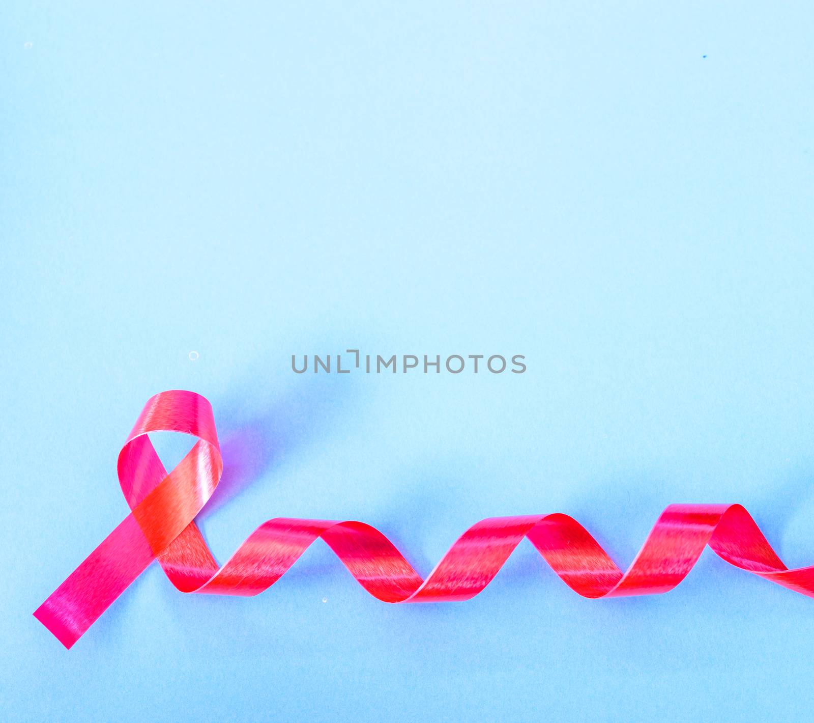 Red Ribbon Support HIV, AIDS on blue background and copy space for use