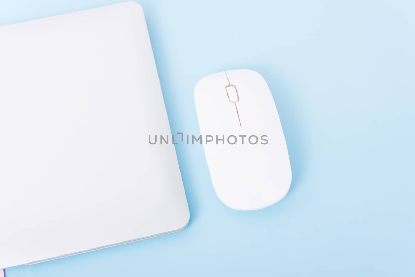 Top view close cover laptop computer notebook and wireless mouse isolated on blue background