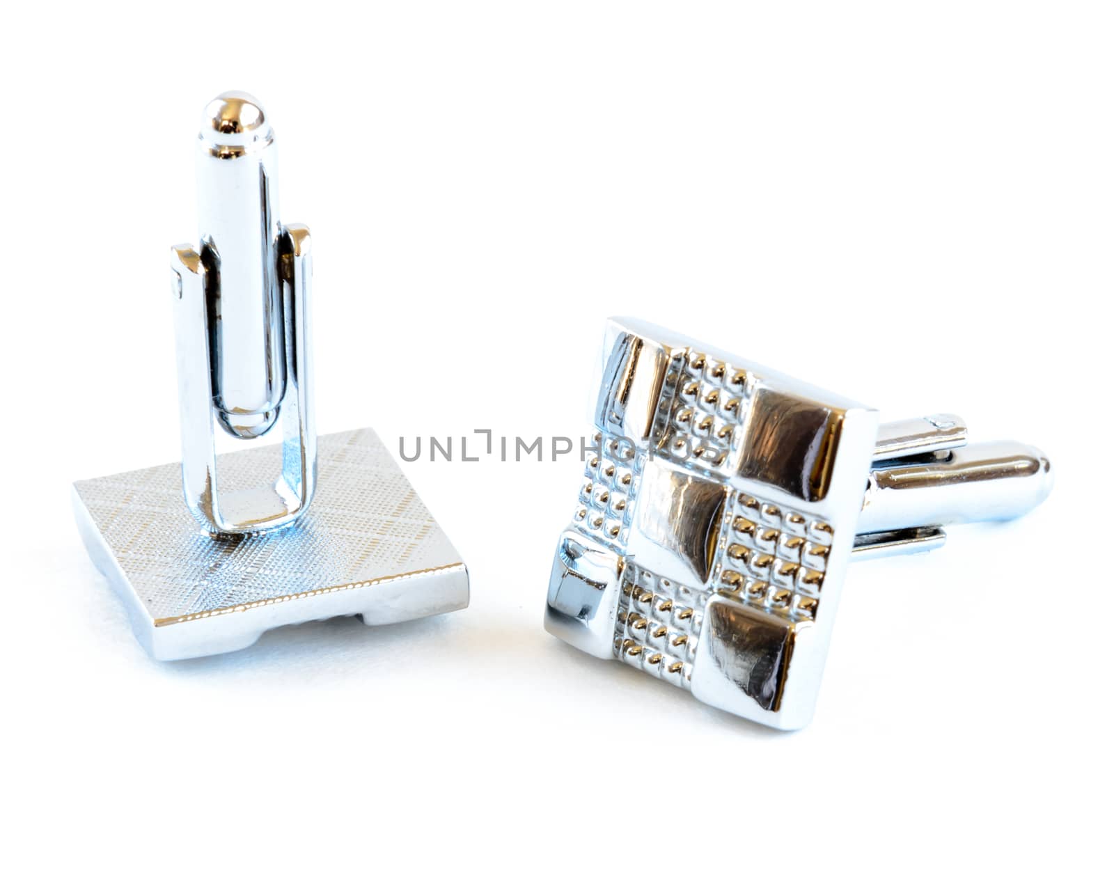 Close-up single pair of modern stainless steel cufflinks isolated on white background. Lifestyle trendy clothing accessories dress with clipping path and copy space.