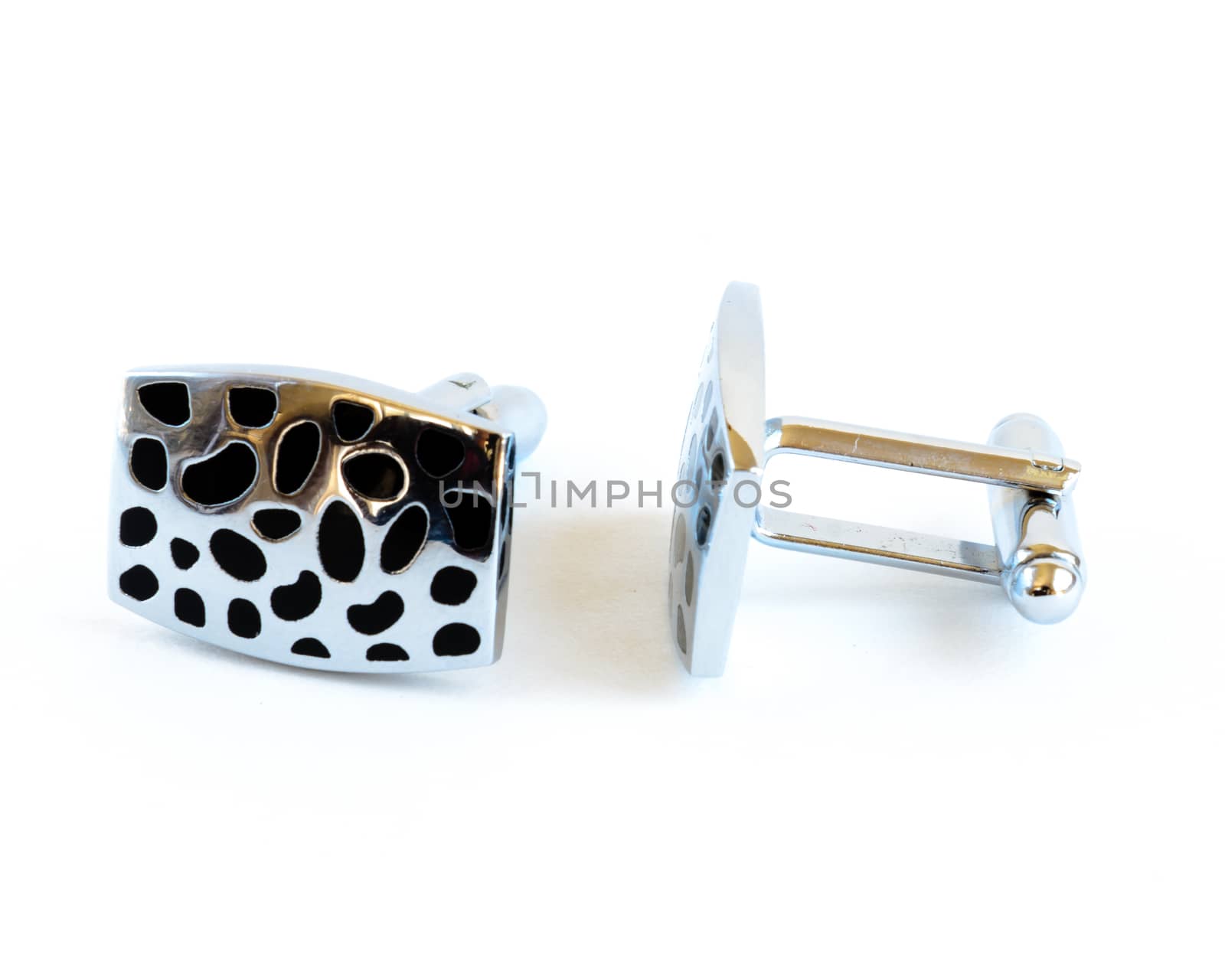 Close-up single pair of modern stainless steel cufflinks isolated on white background. Lifestyle trendy clothing accessories dress with clipping path and copy space.